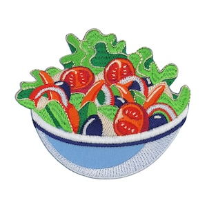 May include: An embroidered patch depicting a salad in a blue bowl. The salad features lettuce, tomatoes, carrots, and olives.