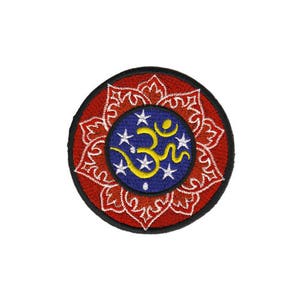 Op de afbeelding: Geborduurde patch met een rood en wit mandala-ontwerp. Het midden van de mandala heeft een blauwe cirkel met een geel Om-symbool en witte sterren.
