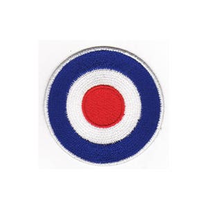 Op de afbeelding: Een rood, wit en blauwe patch in de vorm van een doelwit met een witte cirkel in het midden en een rode cirkel binnen de witte cirkel.