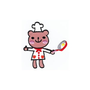 Könnte beinhalten: Ein brauner Bär, der einen weißen Kochhut und eine rote Schürze trägt, hält eine silberne Bratpfanne mit einem Spiegelei.