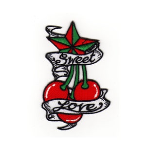 Puede incluir: Parche bordado con una estrella roja y verde, dos cerezas rojas y pancartas blancas que dicen "Sweet" y "Love".