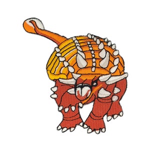 Puede incluir: Un parche bordado de color naranja y rojo de un dinosaurio con púas en la espalda y una expresión feroz.