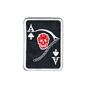 Könnte beinhalten: Schwarz-weiß gestickter Patch eines As Pik Spielkarten mit einem roten Totenkopf und Knochen-Design. Die Karte hat einen weißen Rand.