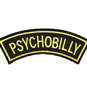 Könnte beinhalten: Schwarzer und gelber gestickter Aufnäher mit dem Text "PSYCHOBILLY" in einer geschwungenen Form.