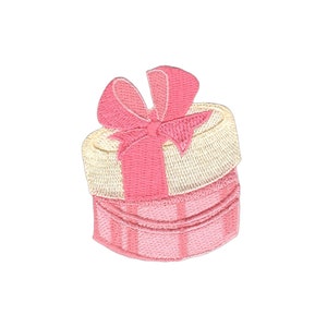 Könnte beinhalten: Eine gestickte Geschenkbox in Rosa und Weiß mit einem rosa Band und Schleife.