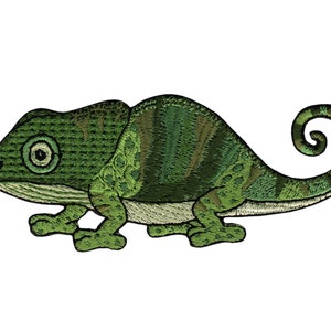 Op de afbeelding: Een groene kameleon met een gekrulde staart. De kameleon is geborduurd met groene, bruine en witte draad.