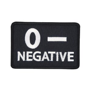 May include: Black embroidered patch with white lettering that reads "O-NEGATIVE".