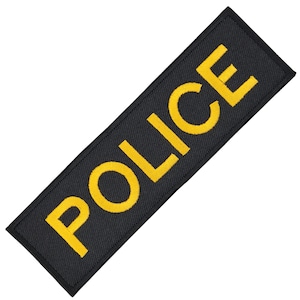 Op de afbeelding: Zwarte stoffen patch met het woord "POLICE" geborduurd in gele draad.