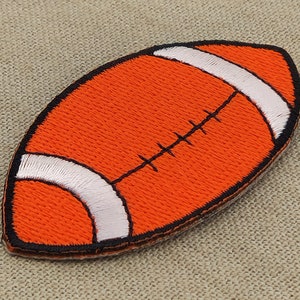 May include: Orange and white embroidered iron-on patch shaped like a football.