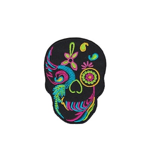 Puede incluir: Parche bordado negro de una calavera de azúcar colorida con diseños florales rosas, verdes, azules y amarillos.