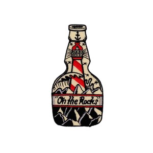May include: Embroidered patch of a bottle with a lighthouse inside, mountains at the bottom, and the text "On the Rocks".