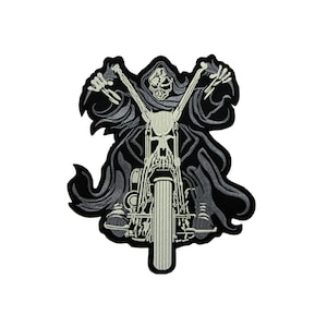 Könnte beinhalten: Schwarz-weiß gestickter Patch eines Skeletts, das ein Motorrad fährt. Das Skelett trägt eine Kapuzenrobe und hält den Lenker. Das Motorrad hat einen großen Vorderreifen.
