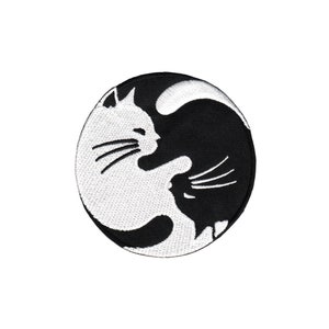 Könnte beinhalten: Schwarz-weiß gestickter Aufnäher mit zwei Katzen in einem Yin-Yang-Design.