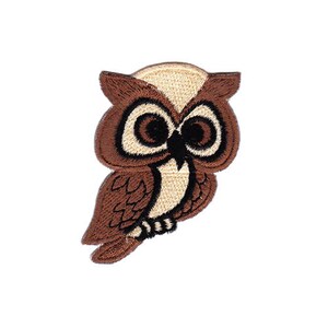 Op de afbeelding: Geborduurde patch van een bruine en beige uil met zwarte ogen.