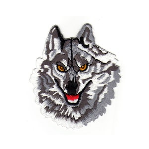 Könnte beinhalten: Gestickter Aufnäher mit dem Gesicht eines Wolfes mit einem weißen und grauen Fellmuster, rotem Maul und orangefarbenen Augen.