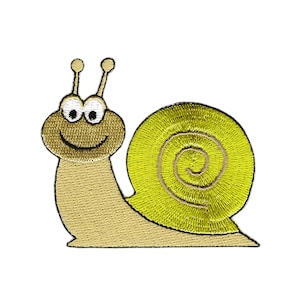 Könnte beinhalten: Eine gestickte Schnecke mit einem lächelnden Gesicht und großen Augen. Die Schnecke ist gelb und braun und kriecht nach rechts.