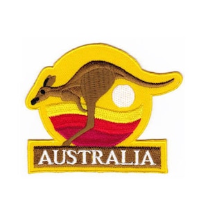 Peut inclure: Un écusson brodé jaune avec un kangourou sautant devant un soleil rouge, jaune et blanc. Les mots "AUSTRALIA" sont écrits en blanc sur une bannière jaune sous le kangourou.