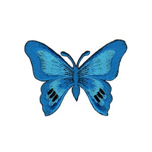 Könnte beinhalten: Ein gestickter blauer Schmetterlingspatch mit schwarzen Akzenten. Der Schmetterling hat ein detailliertes Design mit einem Farbverlauf in Blautönen.