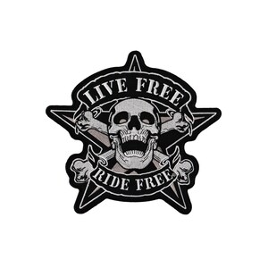 Könnte beinhalten: Schwarzer und weißer gestickter Patch mit einem Totenkopf und gekreuzten Knochen in der Mitte. Der Totenkopf grinst und hat eine Sternform um sich herum. Der Text "Live Free Ride Free" ist um den Totenkopf und die gekreuzten Knochen geschrieben.