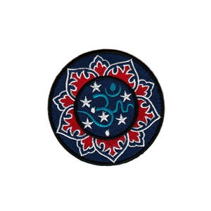 Op de afbeelding: Gestikte patch met een blauw en rood mandala-ontwerp. Het midden van de mandala toont een turquoise Om-symbool omringd door witte sterren.