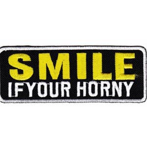 May include: Black and white embroidered patch with yellow text that reads "SMILE IF YOUR HORNY".