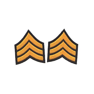 Könnte beinhalten: Zwei goldene gestickte militärische Rangabzeichen mit jeweils drei schwarzen Streifen.