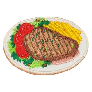Könnte beinhalten: Gestickter Bügel-Patch mit einem Teller Essen mit einem Steak, Pommes Frites, Salat und Tomaten.