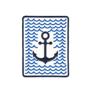 Op de afbeelding: Een blauwe en witte geborduurde patch met een donkerblauwe anker in het midden. Het anker is omgeven door een patroon van blauwe golven.