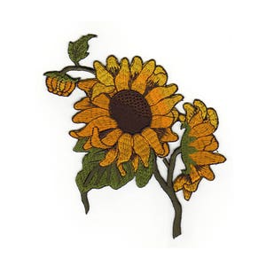 Puede incluir: Parche bordado para planchar con un girasol con pétalos amarillos, un centro marrón y hojas verdes. El girasol está en una rama con dos girasoles más pequeños.