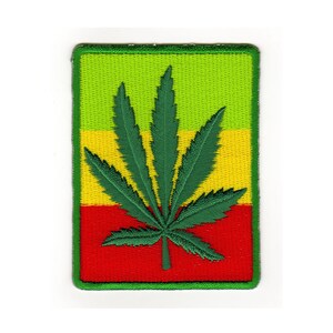 Könnte beinhalten: Grünes Marihuana-Blatt, gestickt auf einem Patch mit gelbem und rotem Hintergrund.
