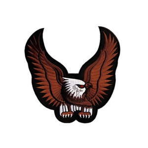 Puede incluir: Parche bordado marrón de un águila calva con plumas blancas y un ojo rojo, con las alas extendidas.