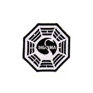 Op de afbeelding: Zwart-witte Dharma Initiative logo-patch met een achthoekige vorm en het woord "DHARMA" in een cirkel.