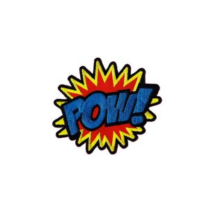 Könnte beinhalten: Ein gestickter Aufnäher mit einem gelben und roten Design und dem Wort "POW!" in blauen Buchstaben.