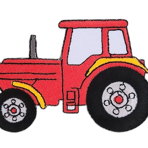 Op de afbeelding: Rode speelgoedtractor met zwarte wielen en gele accenten. De tractor heeft een wit raam en een zwarte uitlaatpijp.