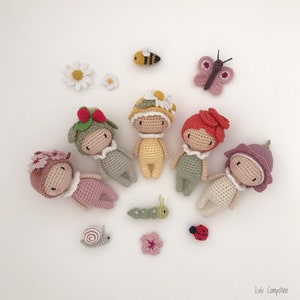 Puede incluir: Una colecci&oacute;n de mu&ntilde;ecas y peque&ntilde;as criaturas hechas a mano con ganchillo, incluyendo una abeja, una mariposa, una oruga, un caracol, una mariquita y flores. Las mu&ntilde;ecas est&aacute;n vestidas con varios colores y adornadas con sombreros y accesorios florales.