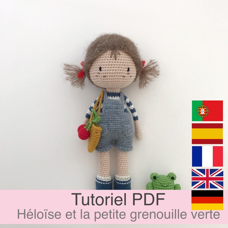 Puede incluir: Tutorial PDF de crochet para hacer una mu&ntilde;eca de ni&ntilde;a y una rana verde. La mu&ntilde;eca lleva un vestido de peto azul y tiene el pelo marr&oacute;n. El patr&oacute;n est&aacute; disponible en varios idiomas.