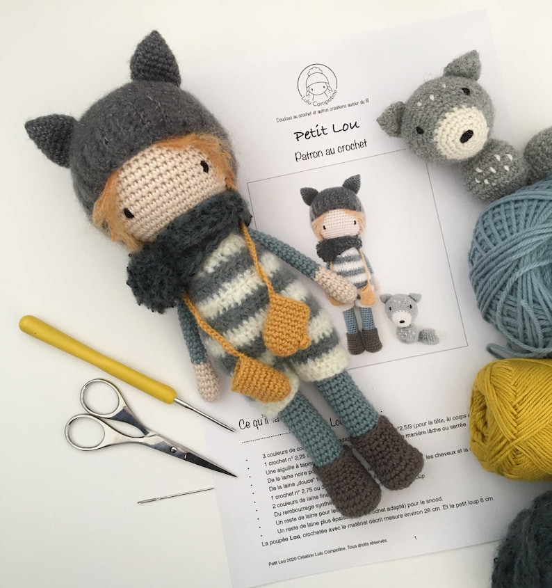 Op de afbeelding: Een haakpatroon voor een kleine wolfpop genaamd "Petit Lou". Het patroon bevat instructies voor het haken van de pop, een kleine wolf en een kleine hond. Het patroon is geschreven in het Frans.