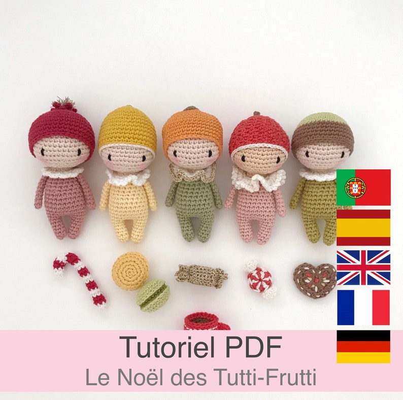 May include: Five crocheted dolls in different colors, each wearing a hat and a bib. The dolls are arranged in a row on a white background. The dolls are surrounded by small crocheted items, including a candy cane, a macaron, a candy, and a heart-shaped cookie. The text "Tutoriel PDF Le No&euml;l des Tutti-Frutti" is written in pink at the bottom of the image. The image also includes flags for Portugal, Spain, the United Kingdom, France, and Germany.