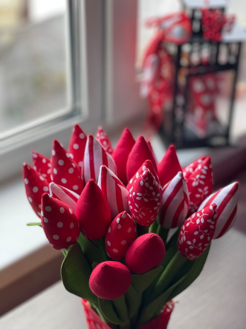 Puede incluir: Un ramo de tulipanes de tela roja y blanca con patrones de lunares, rayas y hojas. Los tulipanes est&aacute;n dispuestos en una maceta roja y blanca.