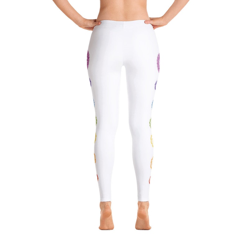 May include: White leggings with a colorful chakra design. The leggings feature a series of rainbow-colored chakra symbols running down the sides. The design includes red, orange, yellow, green, blue, indigo, and purple colors.