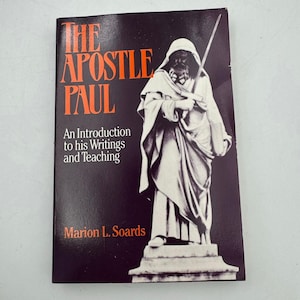 May include: A book titled "The Apostle Paul" with orange lettering on a black background. The cover features a black and white illustration of a robed figure holding a sword. The book is an introduction to his writings and teaching, by Marion L. Soards.
