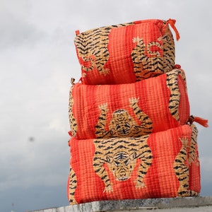 May include: Three stacked orange and black quilted fabric storage boxes with a tiger print design.