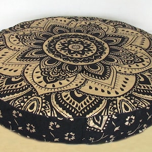 Könnte beinhalten: Runder schwarzer und goldener Bodenkissen mit Mandala-Muster. Das Kissen ist mit einem weichen Material gefüllt und perfekt für Meditation oder Entspannung.