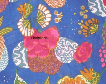 May include: A blue fabric with a colourful floral pattern. The pattern features pink, orange, green and white flowers on a blue background.