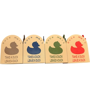 May include: Four duck-shaped cards in brown, blue, green, and red. Each card has the words "DUCK MAIL" and "TAKE A DUCK LEAVE A DUCK" printed on it. The cards are arranged in a row.