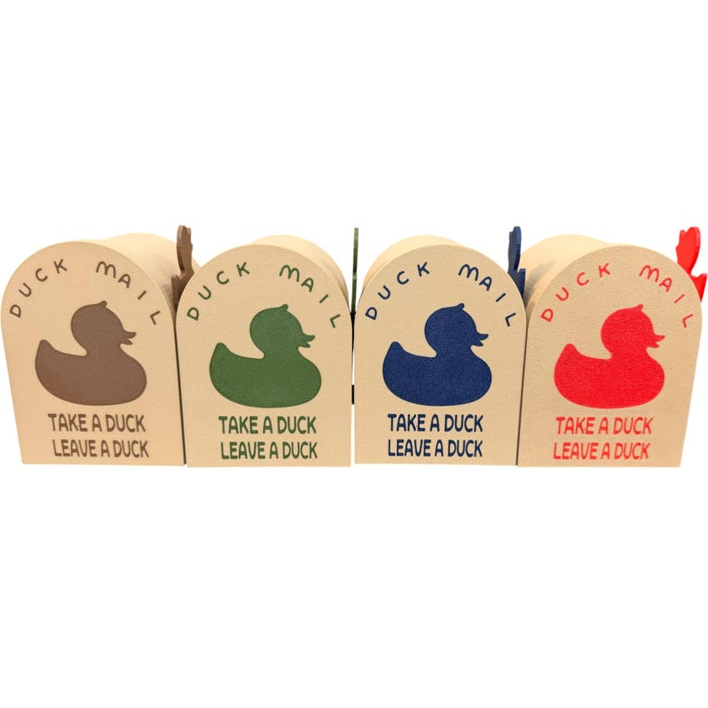 May include: Four small, beige cardboard mailboxes with arched tops. Each features a duck silhouette and the words "DUCK MAIL" and "TAKE A DUCK LEAVE A DUCK." The ducks are brown, green, blue, and red.