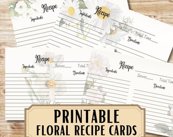 Könnte beinhalten: Eine Sammlung von druckbaren floralen Rezeptkarten. Jede Karte zeigt ein Blumendesign mit weißen Blumen und grünen Blättern. Die Karten haben Linien für Zutaten, Anweisungen und andere Rezeptdetails. Das Wort "Rezept" ist in einer Schreibschrift geschrieben.