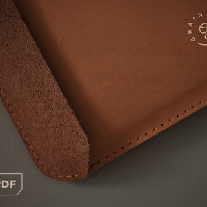Puede incluir: Primer plano de un artículo de cuero marrón con un borde similar al ante. El artículo tiene costuras visibles a lo largo del borde y una superficie lisa. El texto "PDF" está en la esquina inferior izquierda.