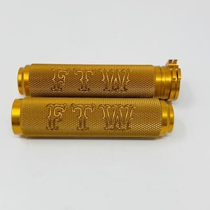 May include: A pair of gold motorcycle grips with the text "FTW" engraved on them.
