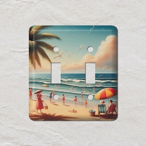 May include: A decorative light switch cover with a beach scene. The artwork shows people on a sandy beach, palm trees, and an umbrella. The scene is set on a sunny day with blue water and a light blue sky.